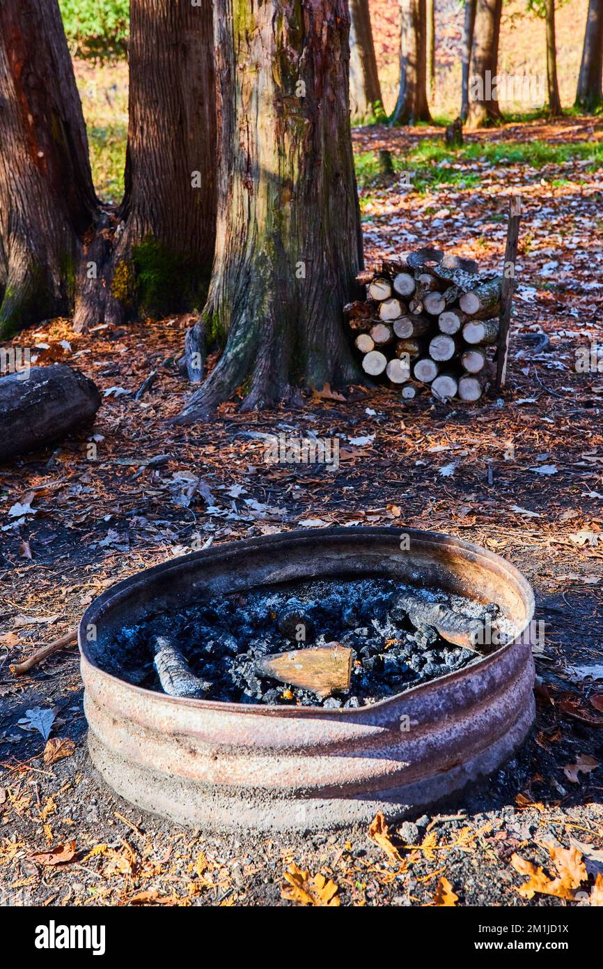 Im Spätherbst können Sie den Campingplatz mit einer einfachen Feuerstelle und einer Holzhalde parken Stockfoto