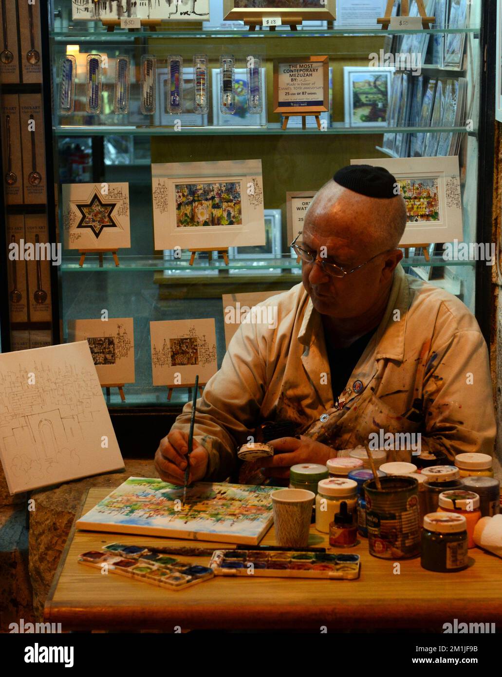 Ein Künstler, der an seinem Gemälde in seinem Atelier im Cardo, jüdisches Viertel, Altstadt von Jerusalem, Israel, arbeitet. Stockfoto