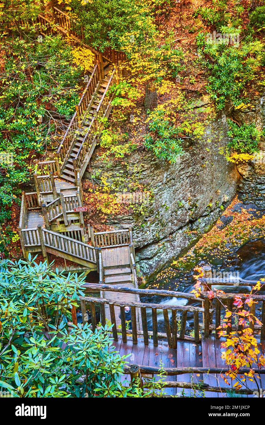 Endlose Treppen über den Fluss und die Klippen hinauf, umgeben von Herbstlaub Stockfoto