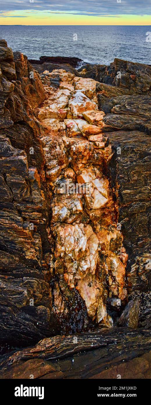 Große mineralische Quarzvene an der felsigen Küste von Maine mit Ozean im Hintergrund Stockfoto