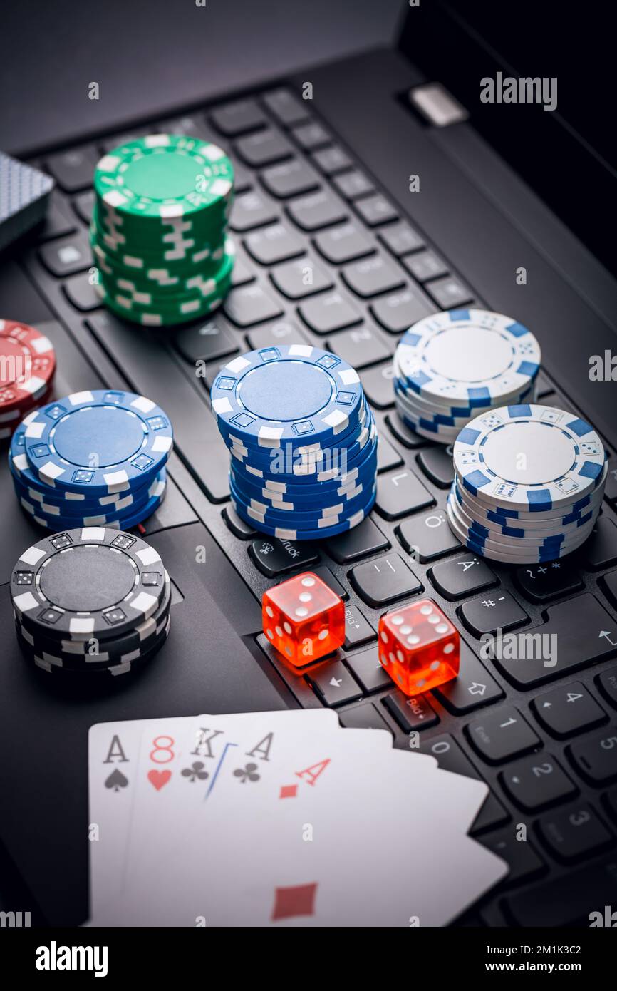 Online-Poker. Chips, Karten und Würfel in der Nähe der Tastatur. Wetten im Internet. Glücksspiel auf der Website und Gewinn. Spielen Sie zu Hause online Poker. Stockfoto