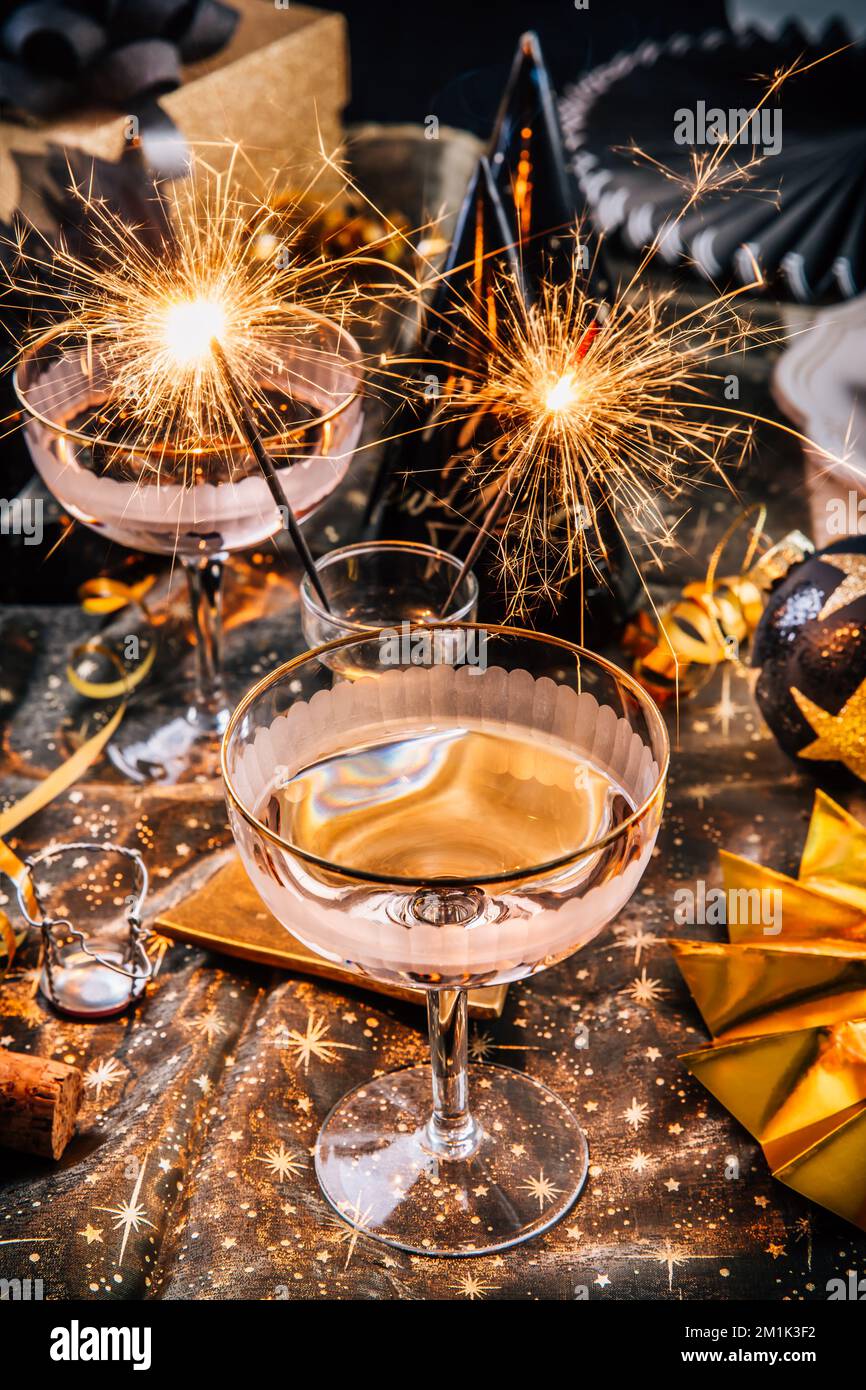 Frohes neues Jahr - zwei Gläser Champagner mit Glitzer auf einem dekorierten festlichen Tisch Stockfoto