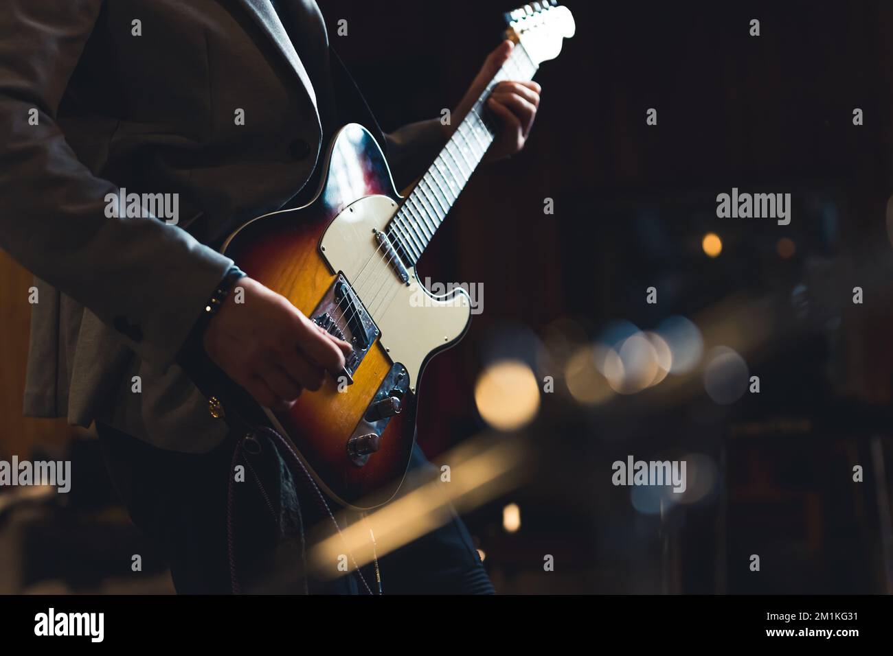Gekürzte Aufnahme eines Gitarrenspielers, der eine E-Gitarre hält. Indoor-Aufnahme eines nicht erkennbaren, kaukasischen Gitarristen in einem Blazer mit professioneller Gitarre. Hochwertiges Foto Stockfoto