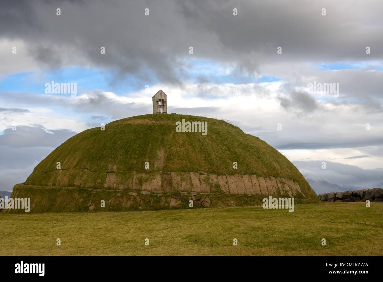 Thufa Hill als Ort für Meditation und Ruhe, basierend auf der lokalen Folklore. Mit grünem Gras bedeckt. Regnerischer, wolkiger Himmel. Grandi, Hafen von Reykjavik, Icel Stockfoto