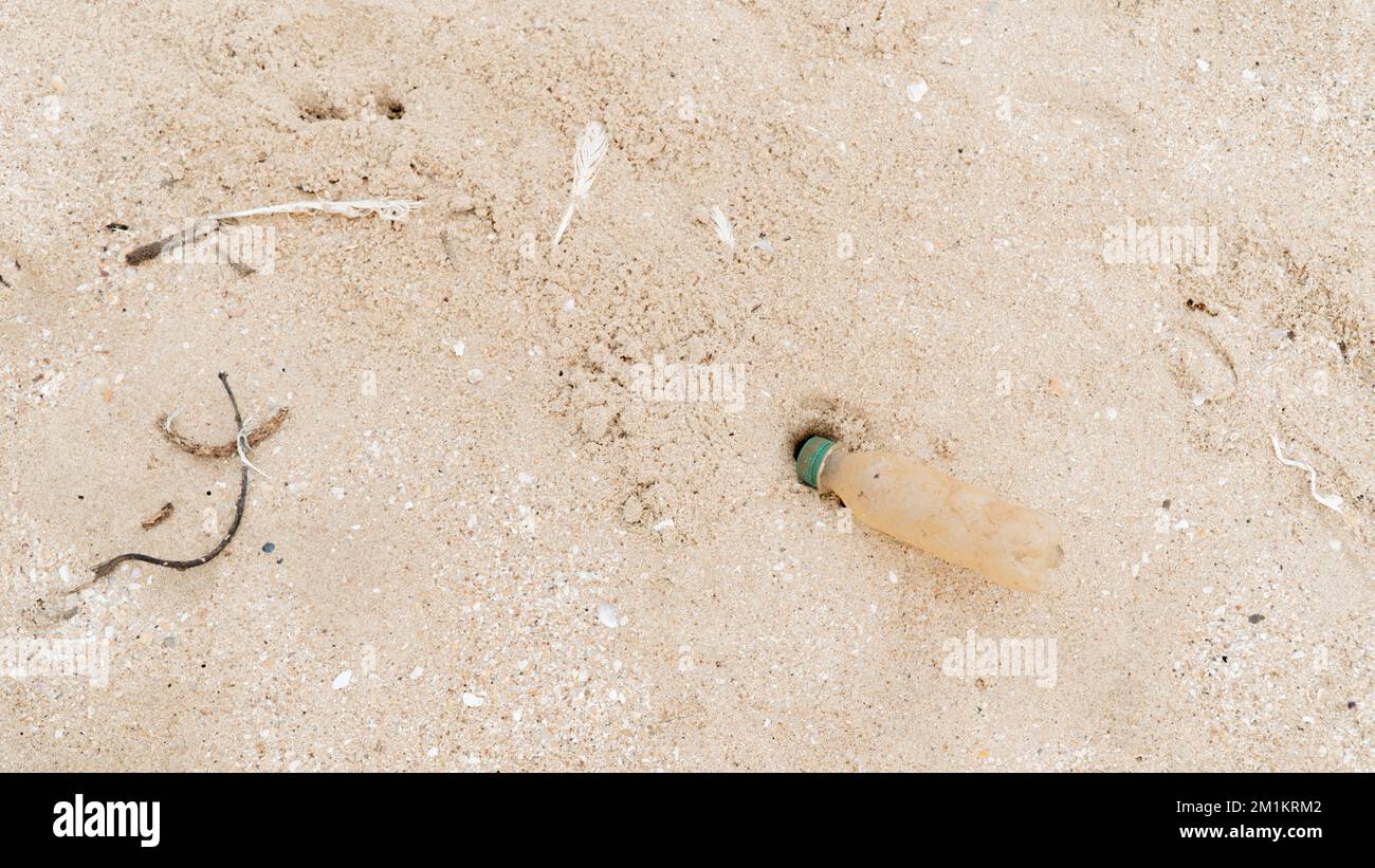 Plastikflasche auf Sand, Umwelt- und Umweltverschmutzung Stockfoto