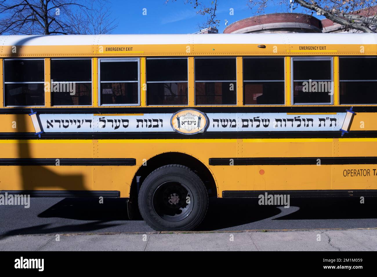 Ein Schulbus mit einem hebräischen Logo für die jüdische Gruppe der Nitra-Chassidischen. In Williamsburg, Brooklyn, New York City. Stockfoto