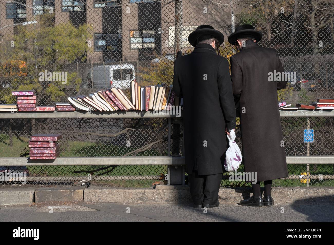 Zwei orthodoxe jüdische Männer, gekleidet in einem schwarzen Laden für religiöse Bücher, bei einem Buchverkauf in Brooklyn, New York City. Stockfoto