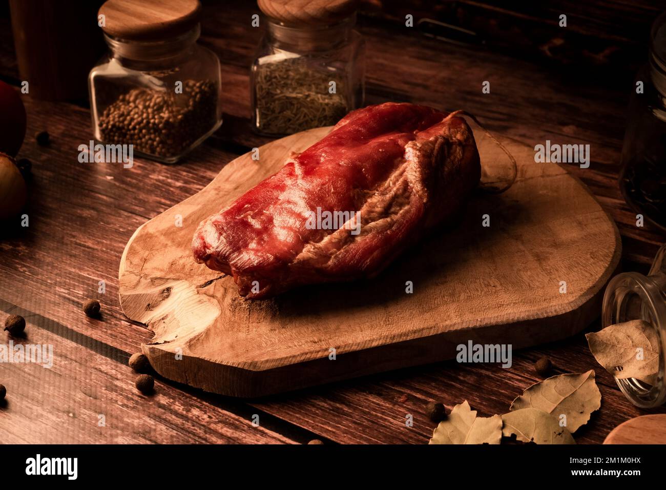 Nahaufnahme von frischem, leckerem Fleisch auf einem Holztisch mit frischen Kräutern und aromatischen Gewürzen Stockfoto