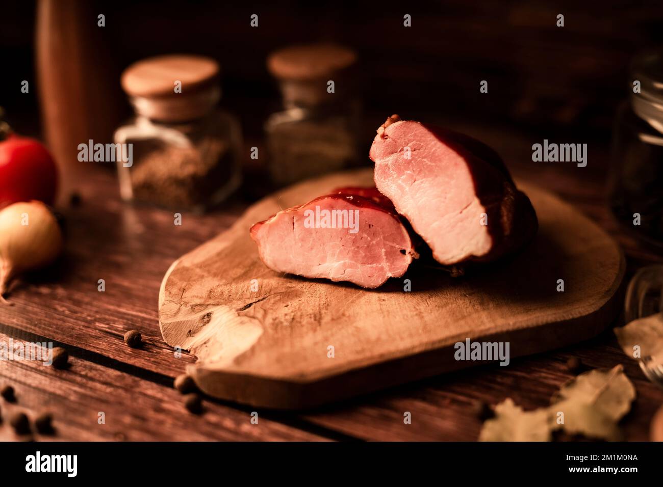 Nahaufnahme von frischem, leckerem Fleisch auf einem Holztisch mit frischen Kräutern und aromatischen Gewürzen Stockfoto