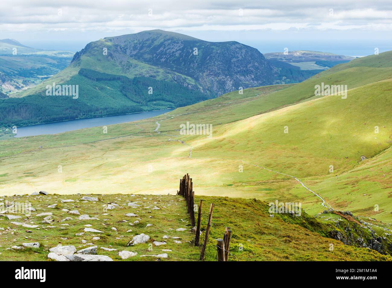 Klettern auf den Snowdon in Nordwales. Blick auf die Hügel und Berge, das grüne Gras und die wunderschönen blauen Seen auf dem Weg zum Gipfel. Stockfoto
