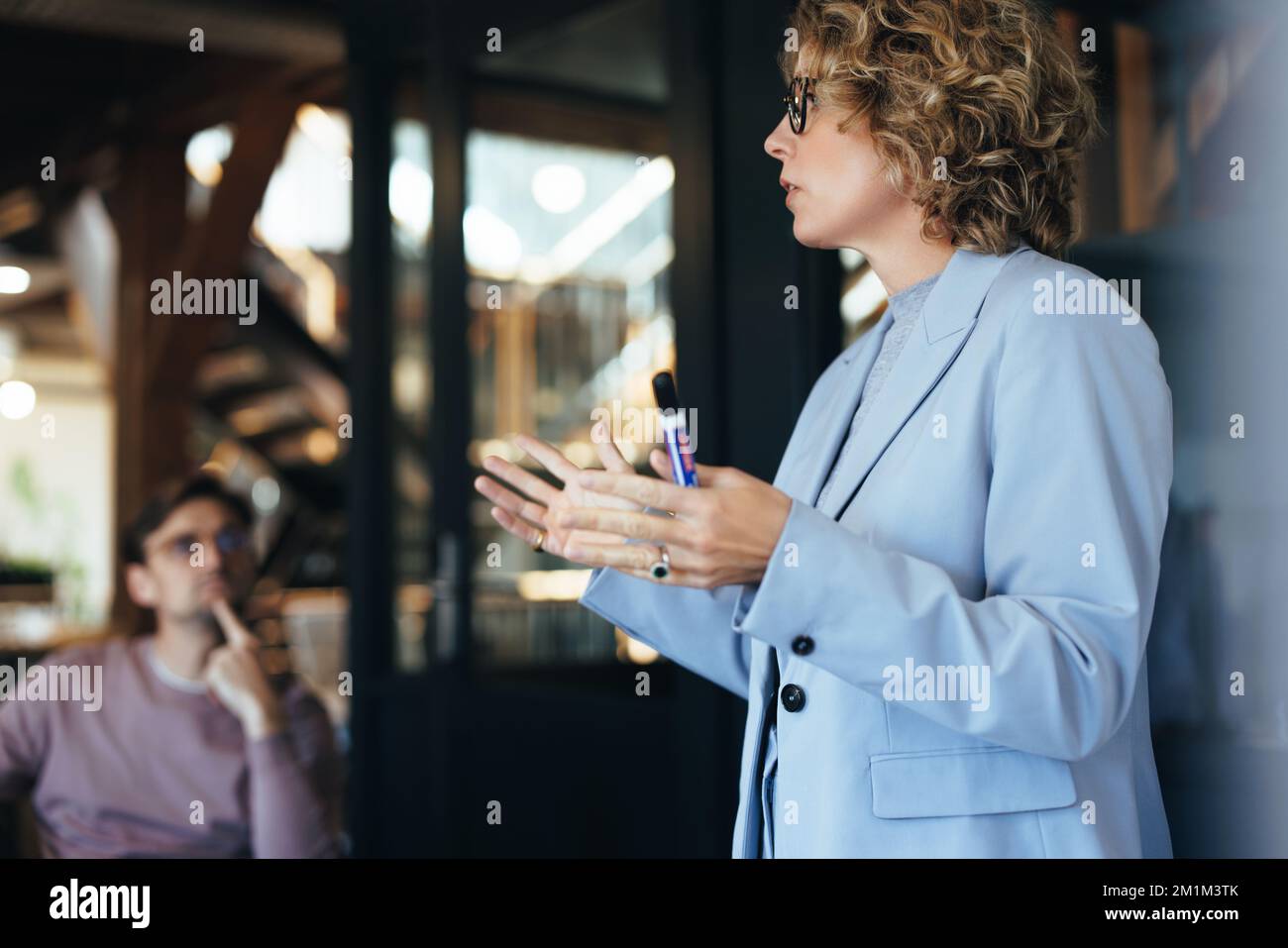 Geschäftsfrau, die eine Konferenz leitet. Frau, die ihren Kollegen eine Idee vorstellt. Teamgespräch in einem modernen Büro. Stockfoto