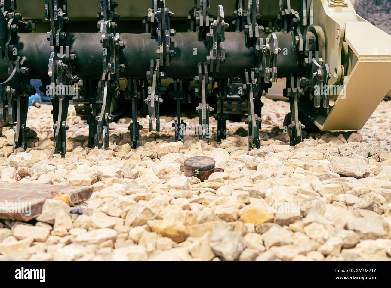 Eine Anti-Personen-Mine auf den Felsen. Minenräumung mit gepanzertem Minenräumfahrzeug. Stockfoto