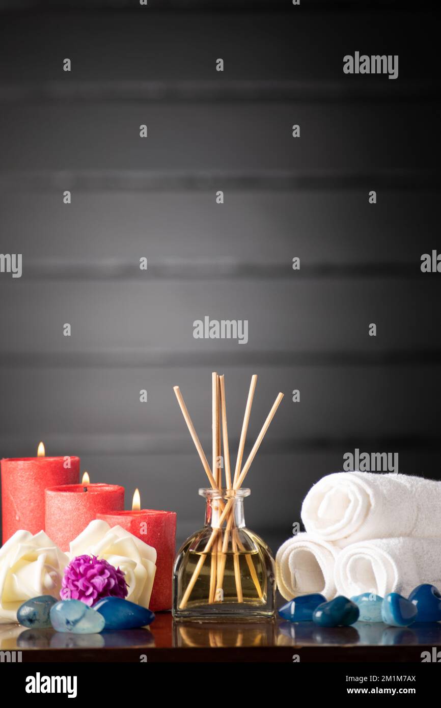Ätherischer Öldiffusor mit Kerzen und Handtuch Stillleben Konzept Stockfoto