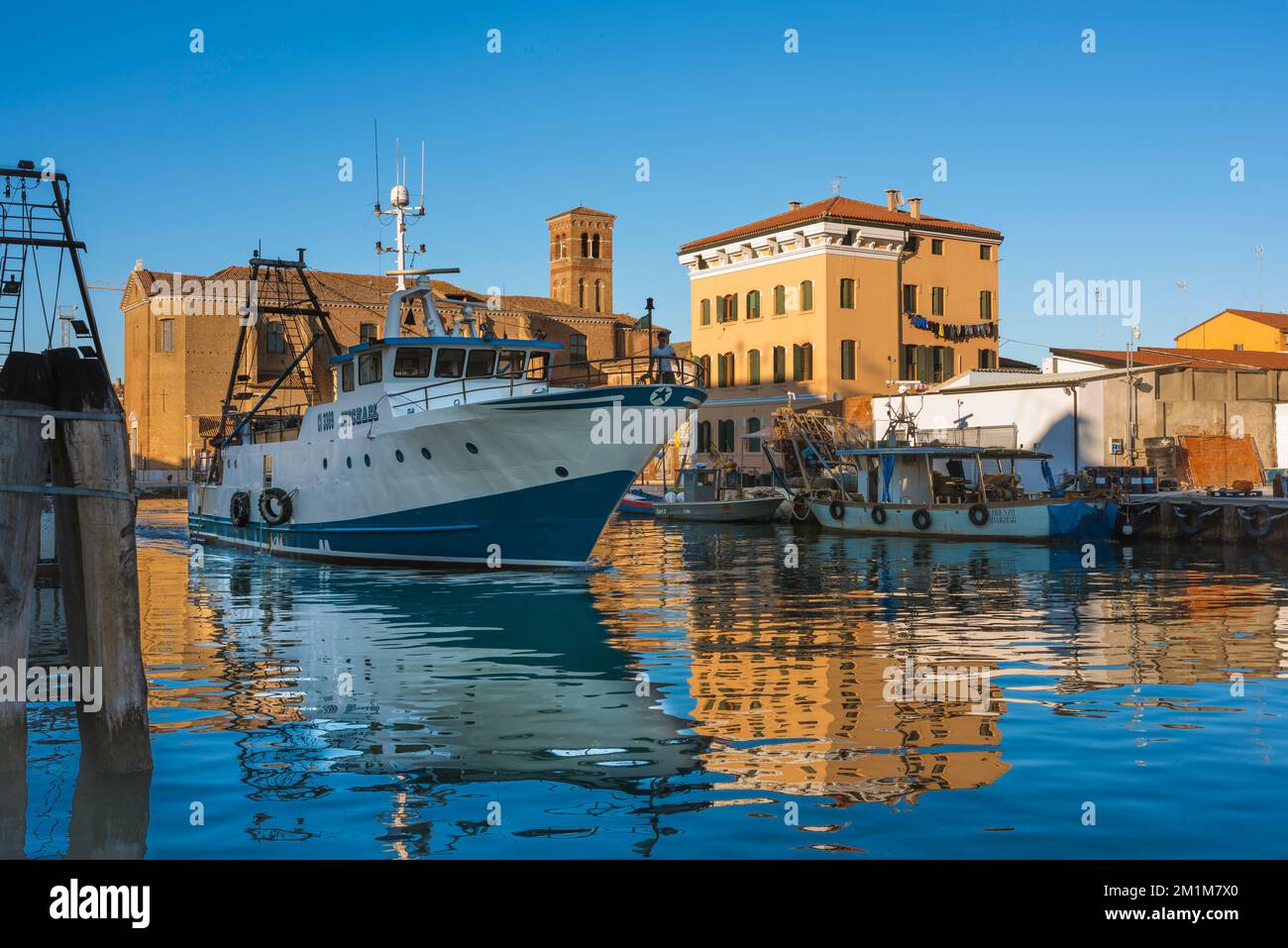 Italien Fischereihafen, Blick im Sommer auf ein großes Fischerboot, das den Hafen von Chioggia, Comune of Veneto, Veneto, Italien anfährt Stockfoto