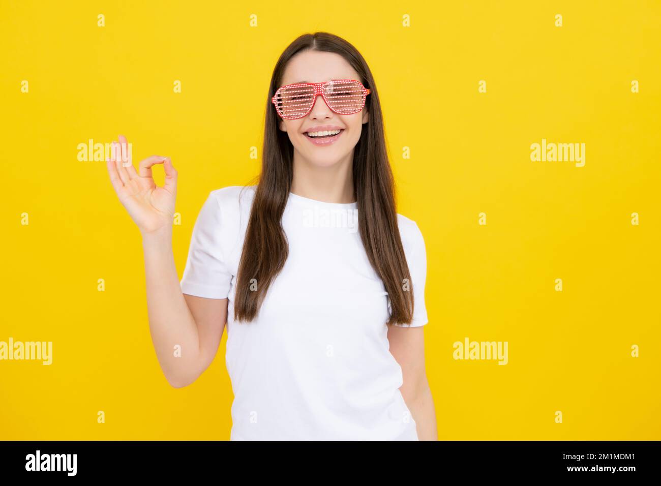 Porträt einer schönen Frau mit lustigen Gläsern. Feiern und feiern. Mädchen mit Spaß, Porträt auf gelbem Hintergrund. Stockfoto