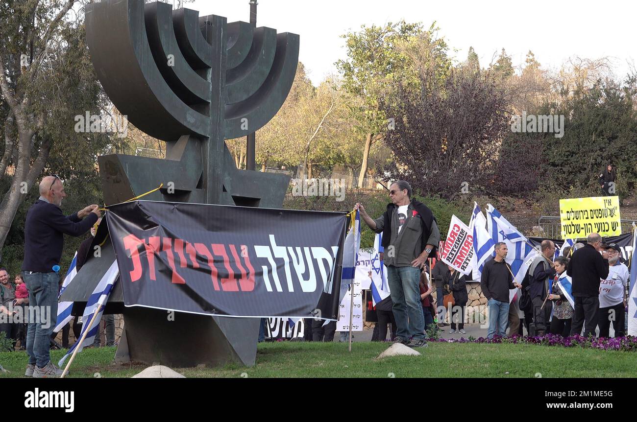 JERUSALEM, ISRAEL - DEZEMBER 12: Linke Aktivisten hängen während einer Demonstration gegen die neue Regierungskoalition, die von Benjamin Netanjahu vor dem israelischen Parlament ausgehandelt wird, ein Banner auf, auf dem "kriminelle Regierung" steht. Kredit: Eddie Gerald/Alamy Live News Stockfoto