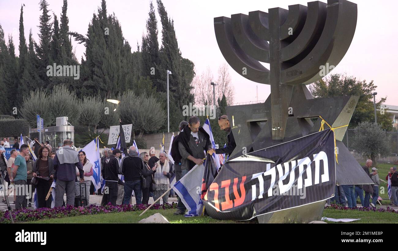JERUSALEM, ISRAEL - DEZEMBER 12: Linke Aktivisten hängen während einer Demonstration gegen die neue Regierungskoalition, die von Benjamin Netanjahu vor dem israelischen Parlament ausgehandelt wird, ein Banner auf, auf dem "kriminelle Regierung" steht. Kredit: Eddie Gerald/Alamy Live News Stockfoto