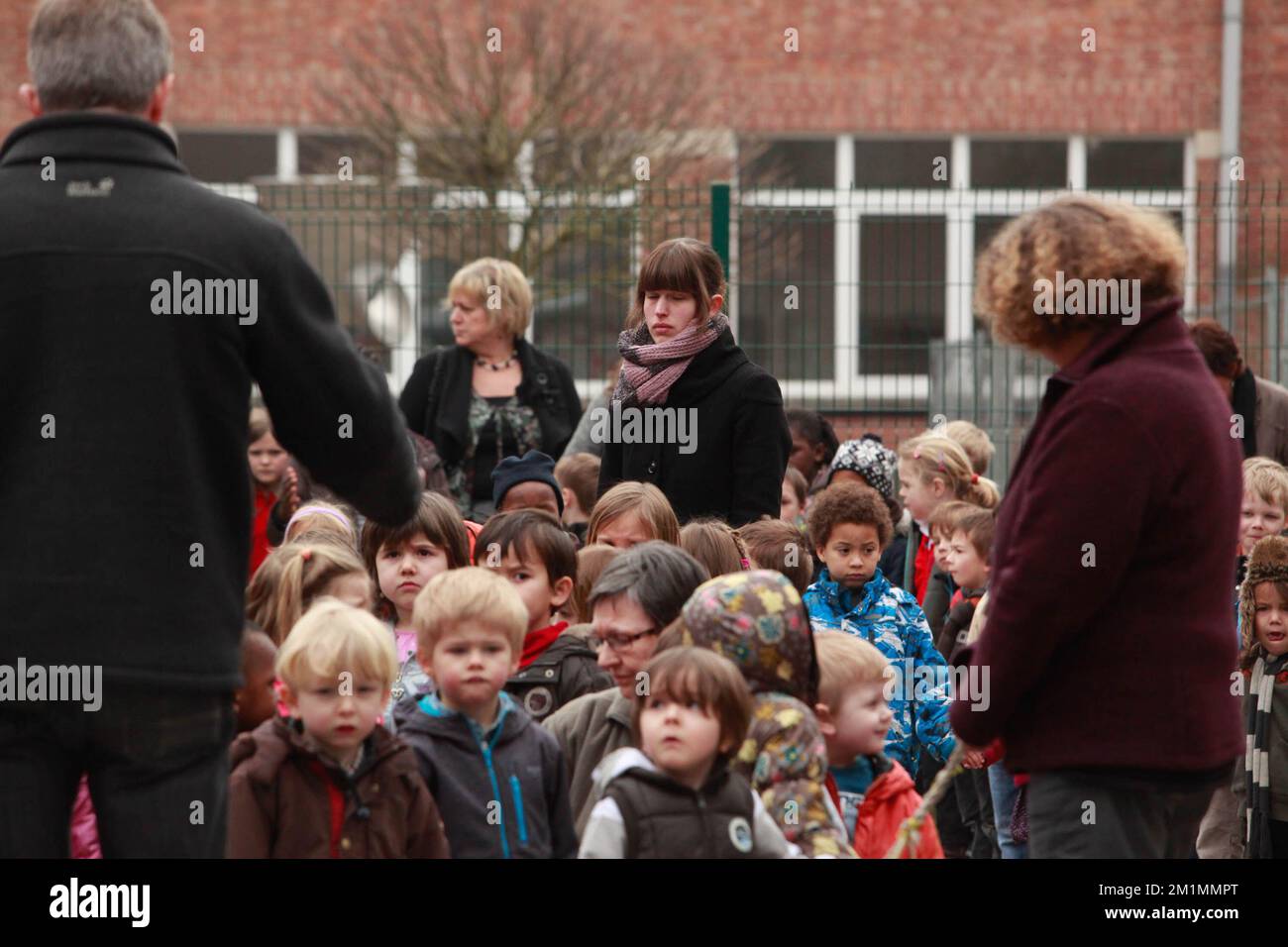 20120316 Uhr - HEVERLEE, BELGIEN: Kinder und Lehrer auf dem Spielplatz während der Schweigeminute am Tag der belgischen nationalen Trauer, rund um die Grundschule (Basisschool - ecole Primaire) Sint-LambertusSchool, in Heverlee, Freitag, 16. März 2012. Bei einem schrecklichen Busunfall am Dienstagabend in einem Tunnel, in Sierre, Valais, Schweiz, 28 Menschen, Darunter 22 Kinder, starben, 24 andere wurden verletzt. Die Kinder aus zwei Schulen von Lommel und Heverlee waren nach dem Skiurlaub auf dem Heimweg. BELGA FOTO CHRISTOPHE LEGASSE Stockfoto