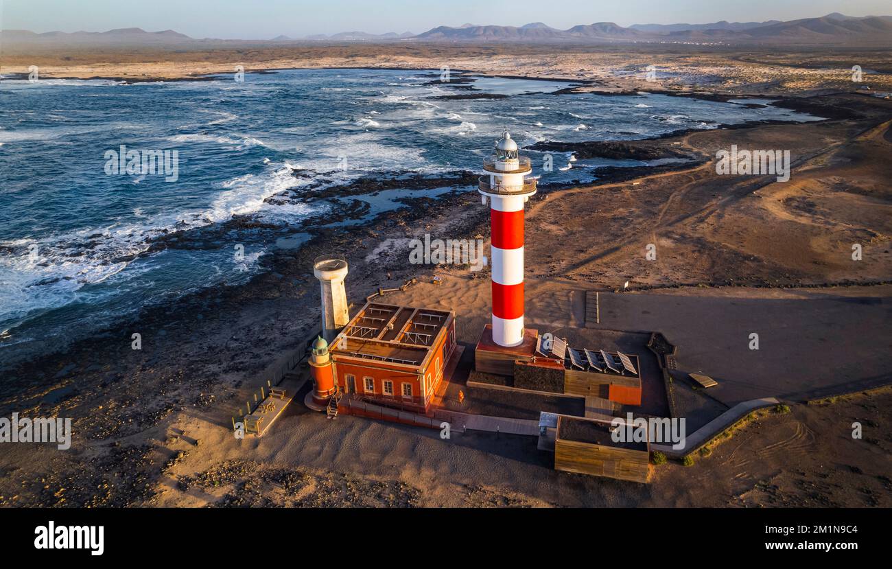 Meereslandschaft mit Leuchtturm bei Sonnenuntergang. Luftaufnahme von der Drohne, Fuerteventura. Kanarische Insel, Dorf El Cotilio. Der Leuchtturm von El Toston Stockfoto