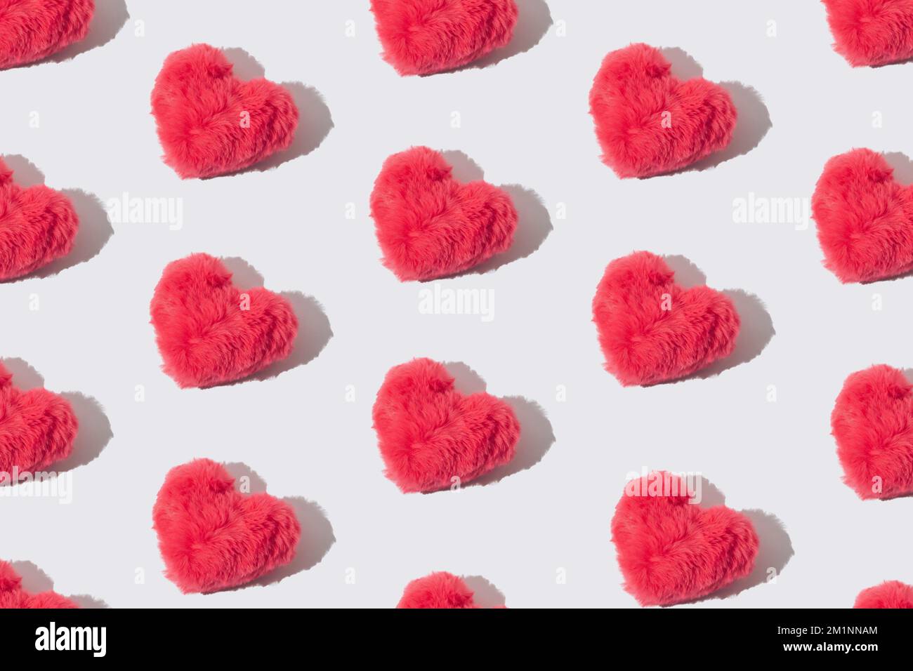 Pinkfarbenes flauschiges Herzmuster auf weißem Hintergrund. Stockfoto