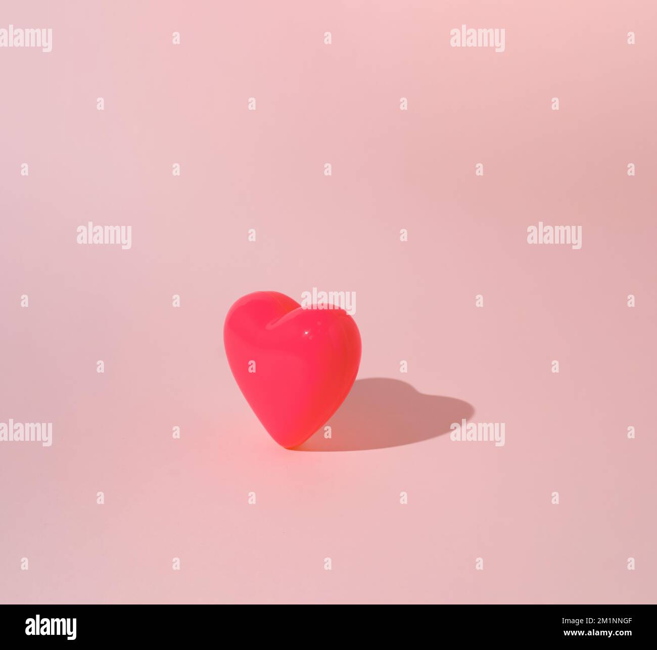 Rosa Herz auf pastellfarbenem Hintergrund. Minimales Valentinstag-oder-Liebe-Konzept. Stockfoto