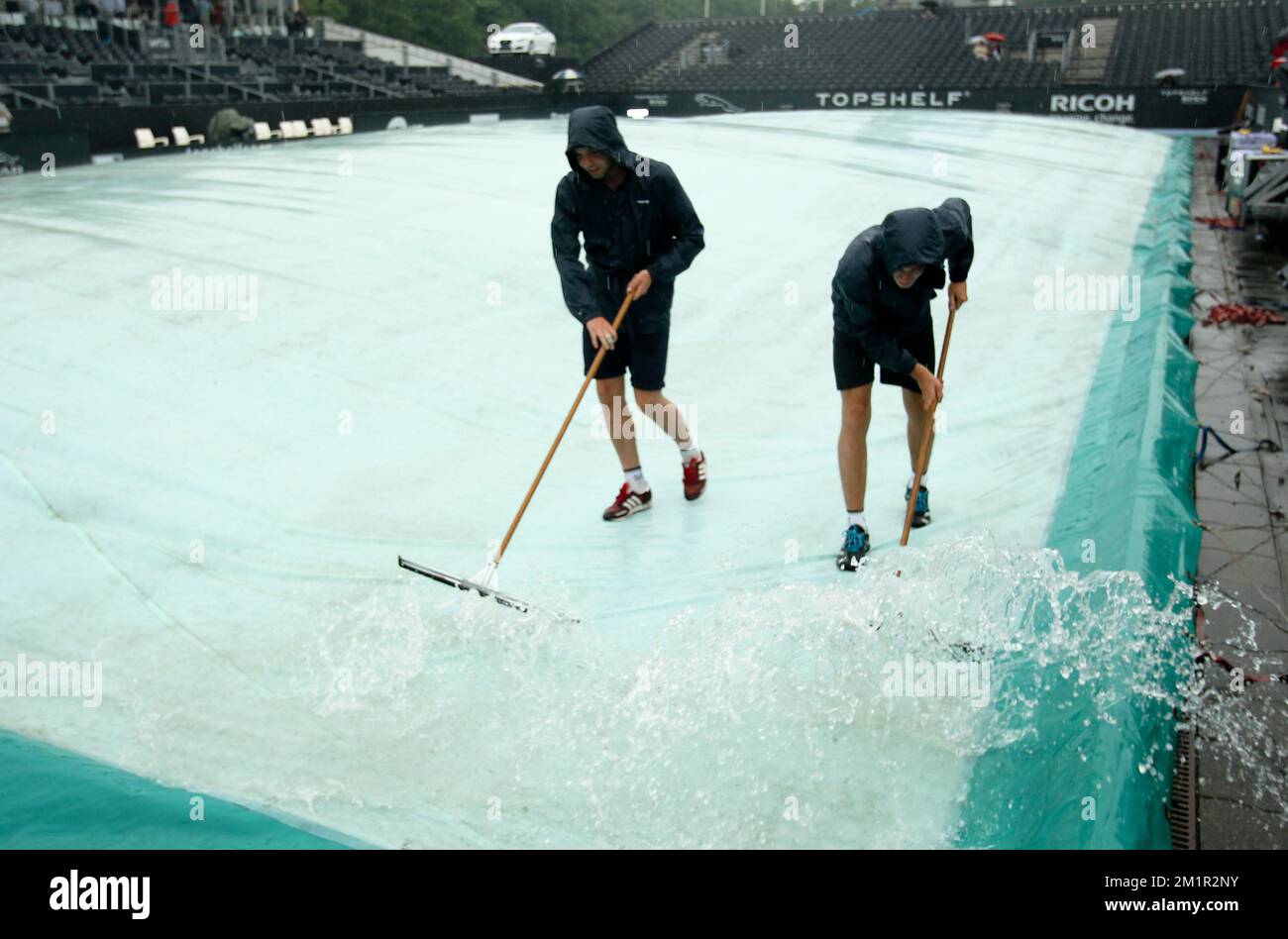 Abbildung zeigt, wie das Wasser auf dem Platz beim Topshelf Open WTA/ATP-Tennisturnier in Rosmalen, Niederlande, am Donnerstag, den 20. Juni 2013 gereinigt wird. Stockfoto