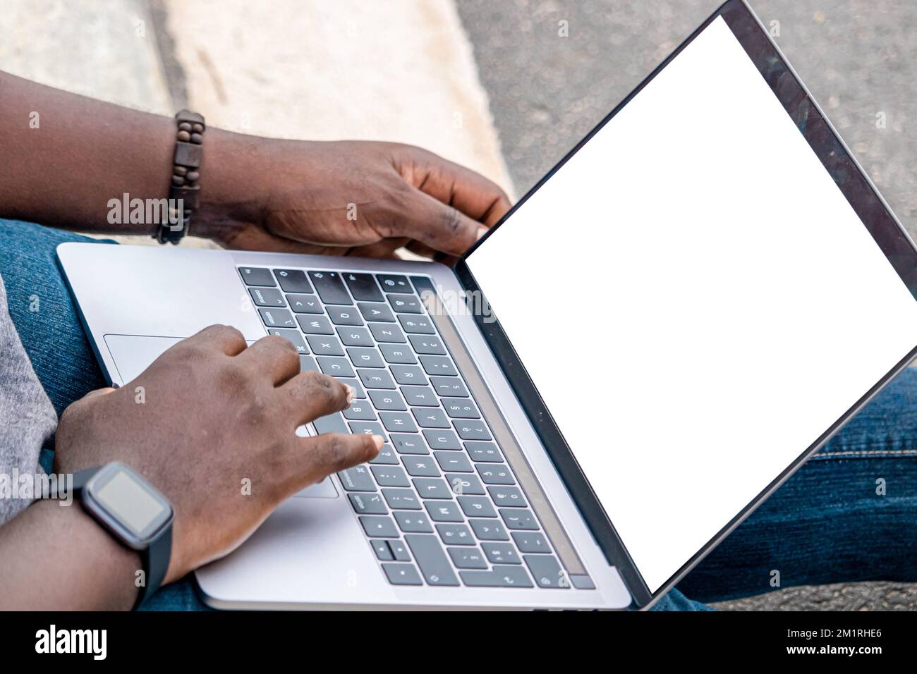 Handporträt eines afrikanischen Webentwicklers, der mit seinem Laptop und einer Smartwatch arbeitet. Stockfoto