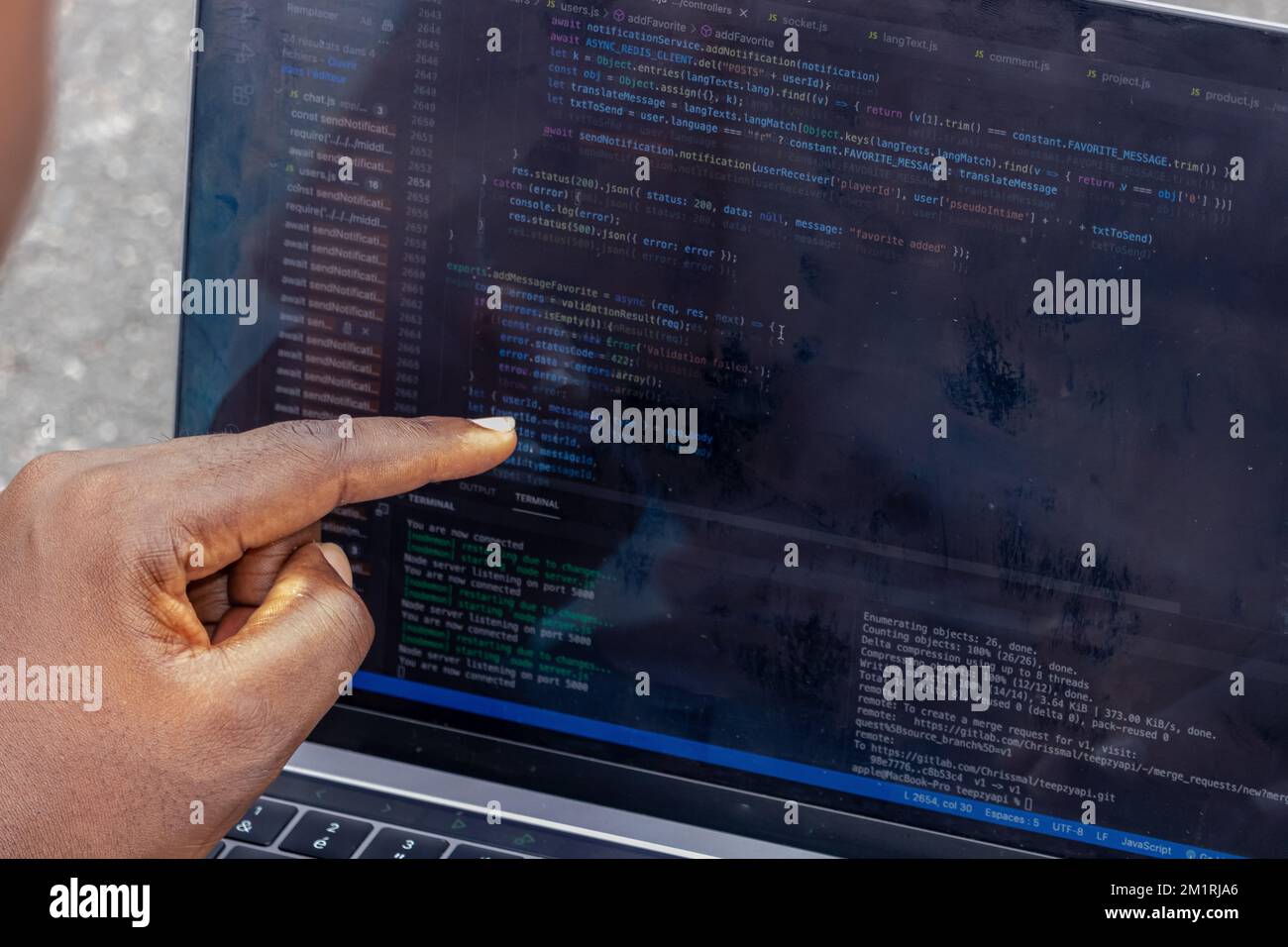 Handporträt eines afrikanischen Webentwicklers, der mit dem Finger auf eine Zeile Computercode zeigt Stockfoto