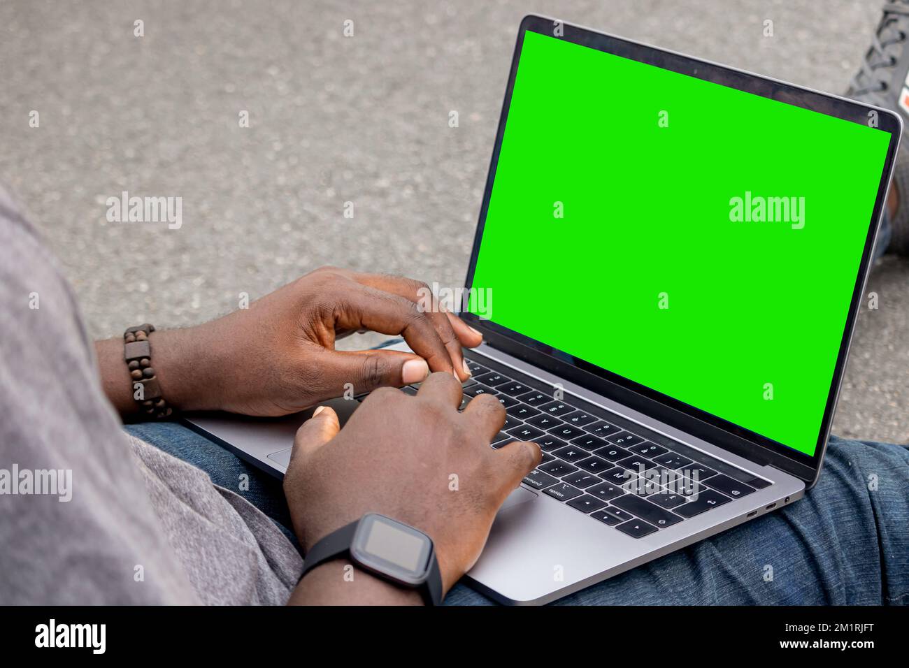 Handporträt eines afrikanischen Webentwicklers, der mit seinem Laptop und einer Smartwatch arbeitet. Stockfoto