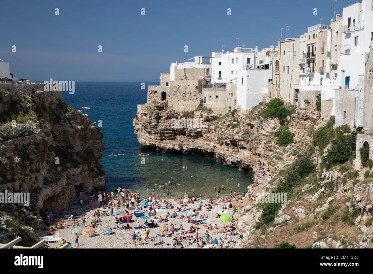 Blick auf den Strand und die Altstadt auf Kalksteinklippen von der Ponte Borbonico su Lama Monachile Brücke, Polignano A Mare, Apulien, Italien, Europa Stockfoto