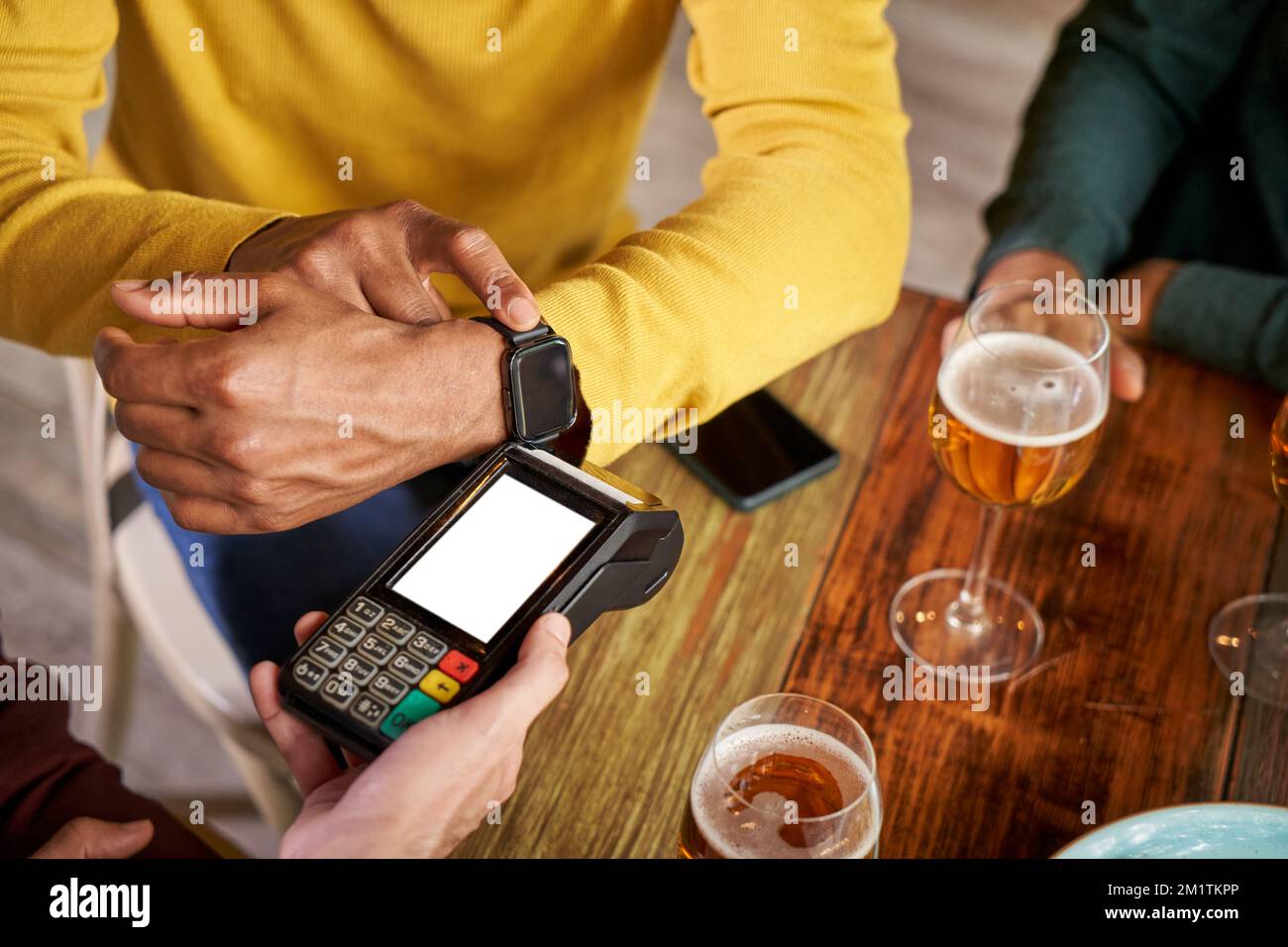 Kunden, die per SmartWatch in einer Bar drahtlos oder kontaktlos bezahlen Stockfoto