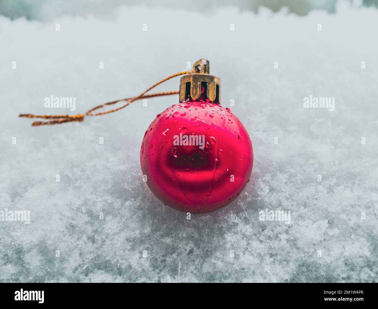 Weihnachtskugel im Schnee, einzelne rote Kugel Stockfoto