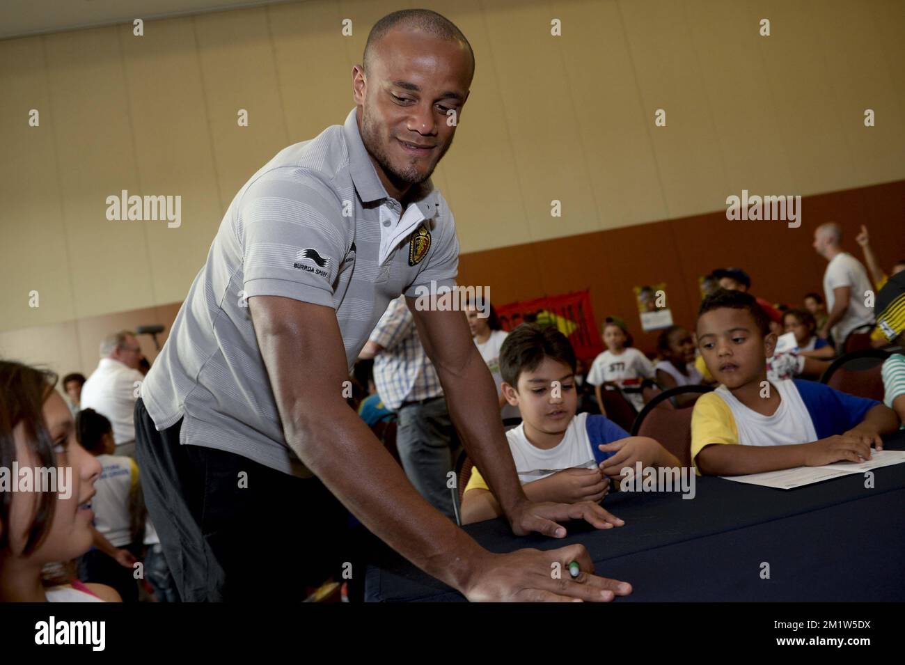 Der belgische Kapitän Vincent Kompany wurde während der FIFA-Weltmeisterschaft 2014 am Dienstag, den 24. Juni 2014 in Mogi das Cruzes, Brasilien, als Spieler auf Kinder treffen, im Rahmen eines Projekts anpassbarer Brillen (billiger als herkömmliche Brillen) mit Blick auf den Weltverband und die belgische Fußballnationalmannschaft Red Devils dargestellt. Die Red Devils führen seine Gruppe mit zwei Siegen an, und sie werden am Donnerstag, den 26. Juni, ihr drittes Spiel in Gruppe H gegen Korea spielen. BELGA FOTO DIRK WAEM Stockfoto