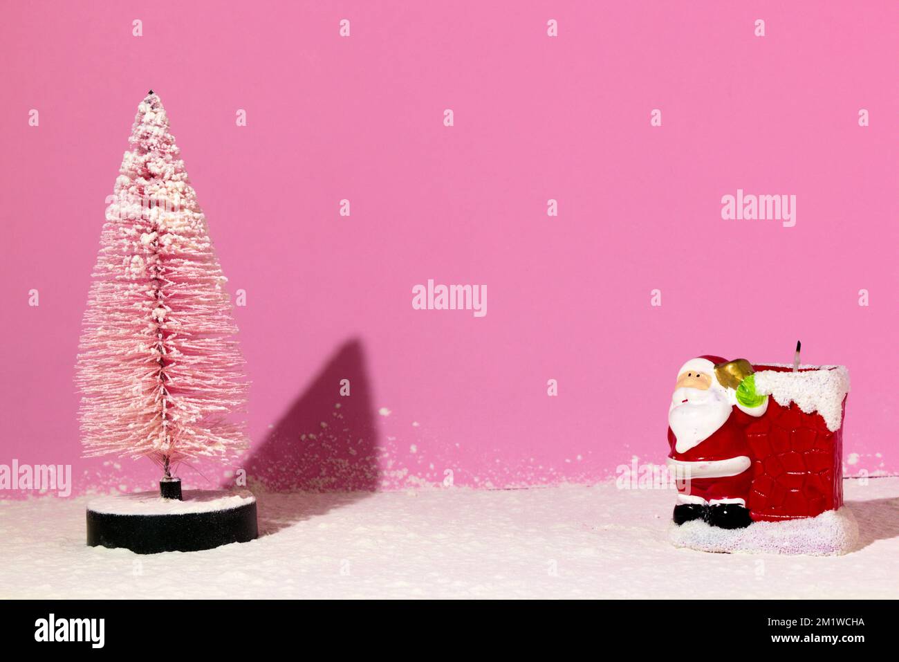 weihnachtsbaum und weihnachtsmann Kerze auf schneeweißem Hintergrund, kreatives Weihnachtskonzept Stockfoto