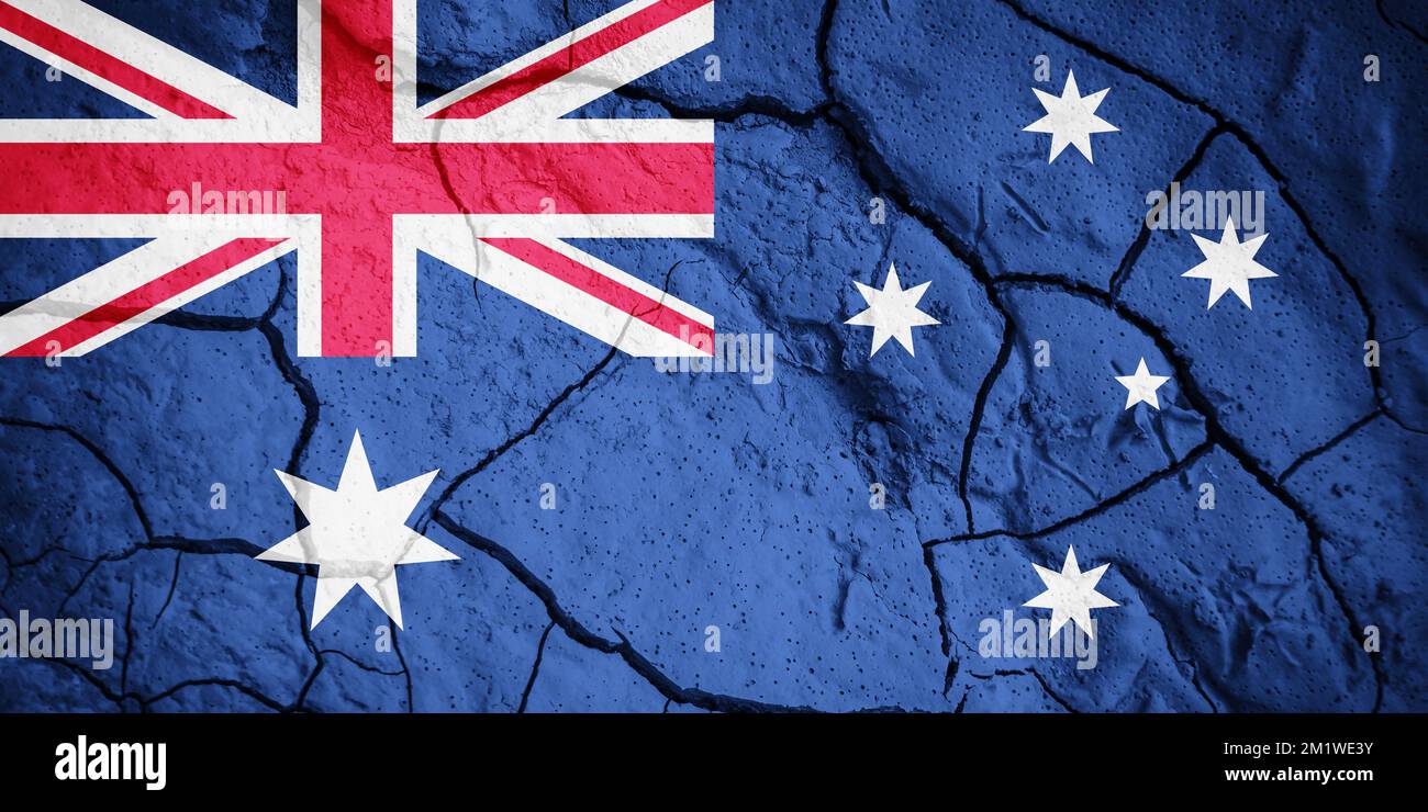 Flagge Australiens. Australisches Symbol. Flagge auf dem Hintergrund von trockener, gerissener Erde. Australische Flagge mit Dürrekonzept Stockfoto