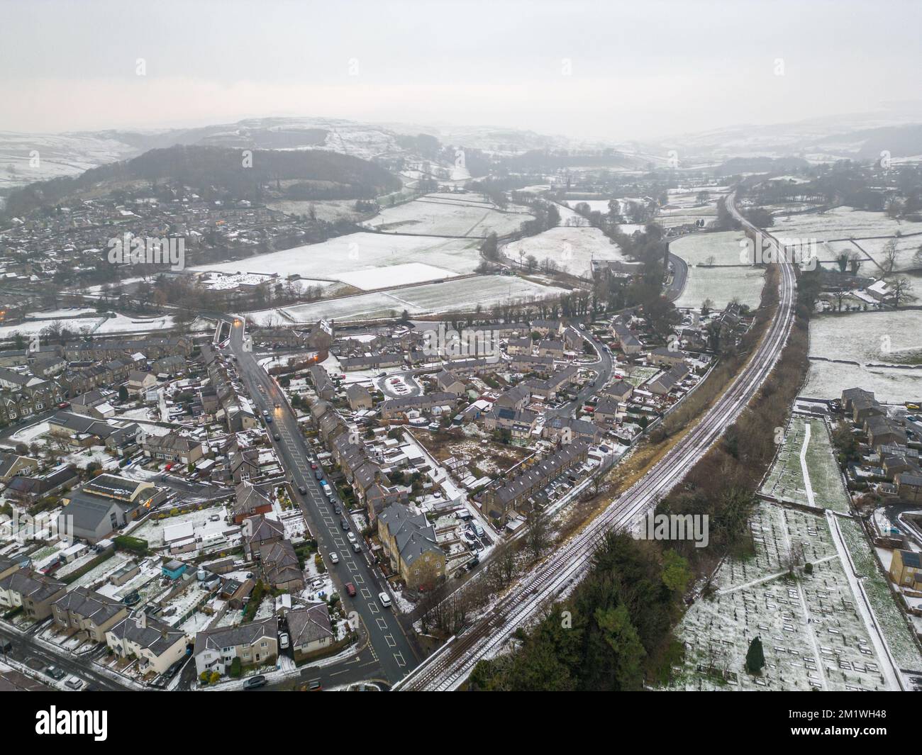 Settlement, Großbritannien. 13.. Dezember 2022 UK Weather Luftaufnahme des Schnees, der in den Yorkshire Dales verblieben ist, mit Dächern von Häusern in Niederwald und den umliegenden Hügeln bedeckt mit Schnee und starkem Frost. Den ganzen Tag über blieb eine Nebeldecke mit Temperaturen unter dem Gefrierpunkt. Kredit: Bradley Taylor / Alamy News Stockfoto