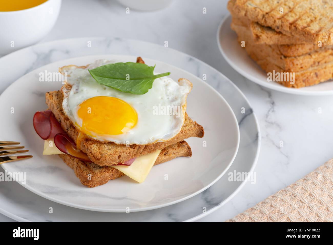 Sandwich mit einem Spiegelei, Speck, Käse und Spinat Stockfoto