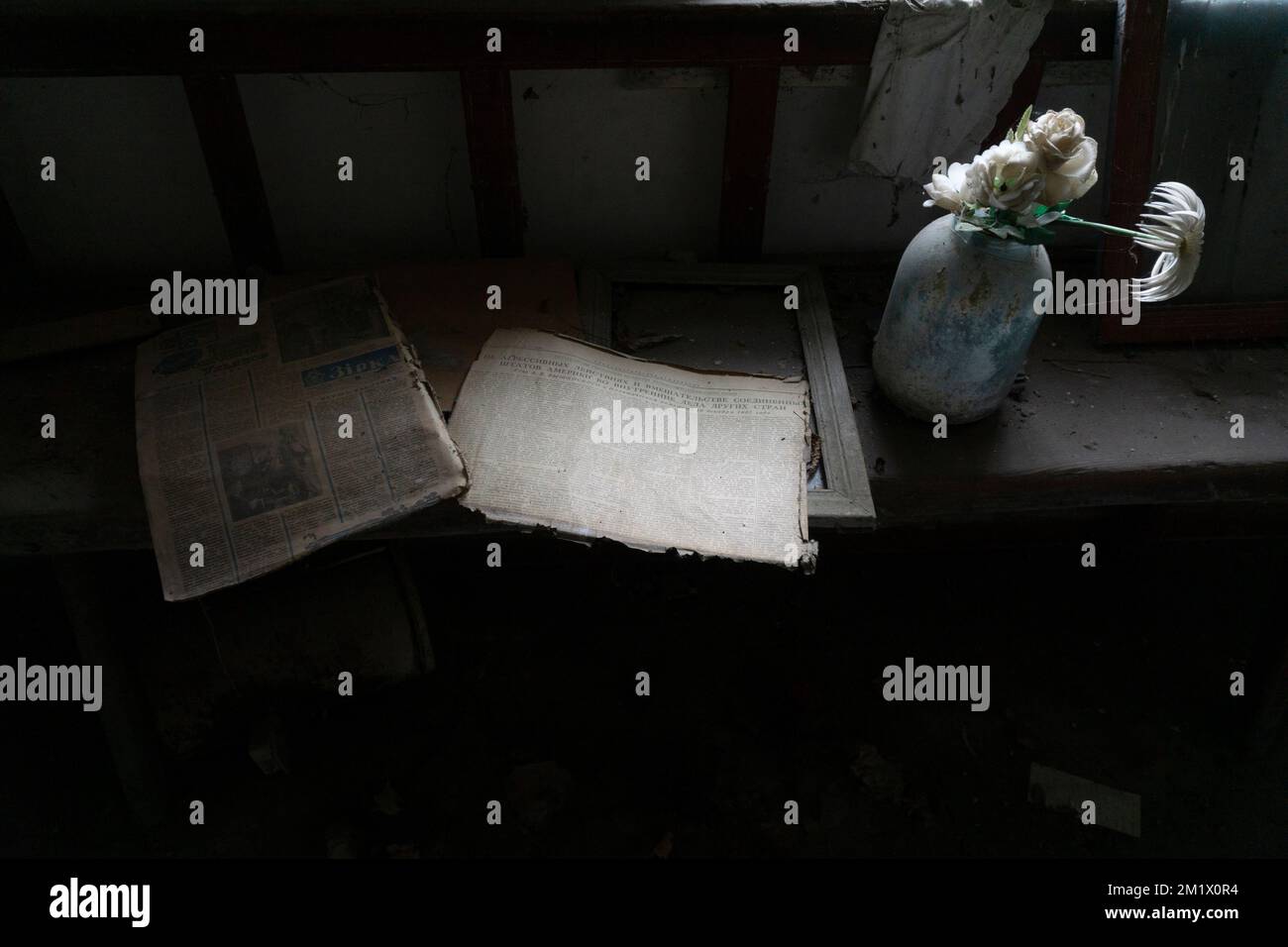 Alte Bücher und Zeitschriften mit Blumen über Holztisch in der tschernobyl-Sperrzone Stockfoto