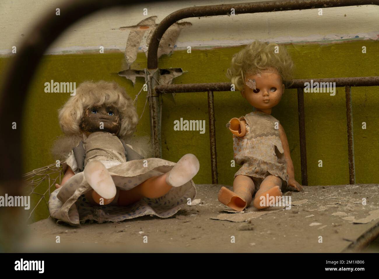 Zwei Puppen über einem rostigen Bett in einem verlassenen Kindergarten in der radioaktiven Sperrzone von tschernobyl Stockfoto