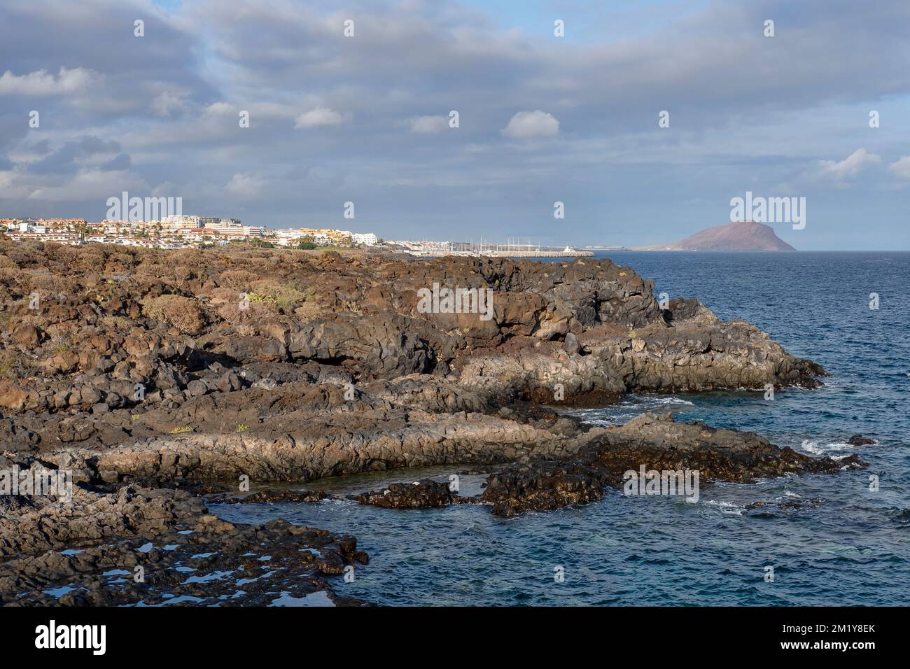 Felsige Ufer und tiefblaues Wasser, in der Nähe des zerklüfteten vulkanischen Wanderwegs, der das Naturdenkmal Montana Amarilla und das Golfdorf Amarilla verbindet Stockfoto