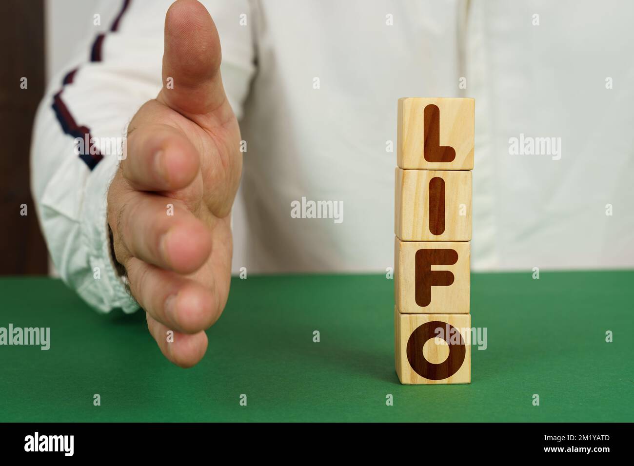 Geschäftskonzept. Auf einer grünen Oberfläche Würfel mit der Aufschrift - LIFO. Der Mann streckt seine Hand aus. Stockfoto