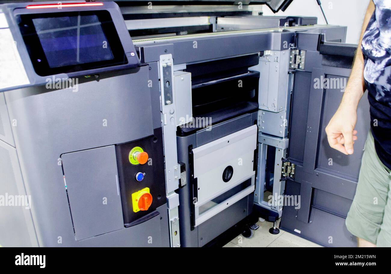 Ein Arbeiter und ein großer industrieller Pulver-3D-Drucker in einem Labor in einer Fabrik. Multi Jet Fusion Industrieanlagen. Neuer moderner 3D-Druck, additive progressive Technologie. MJF Stockfoto