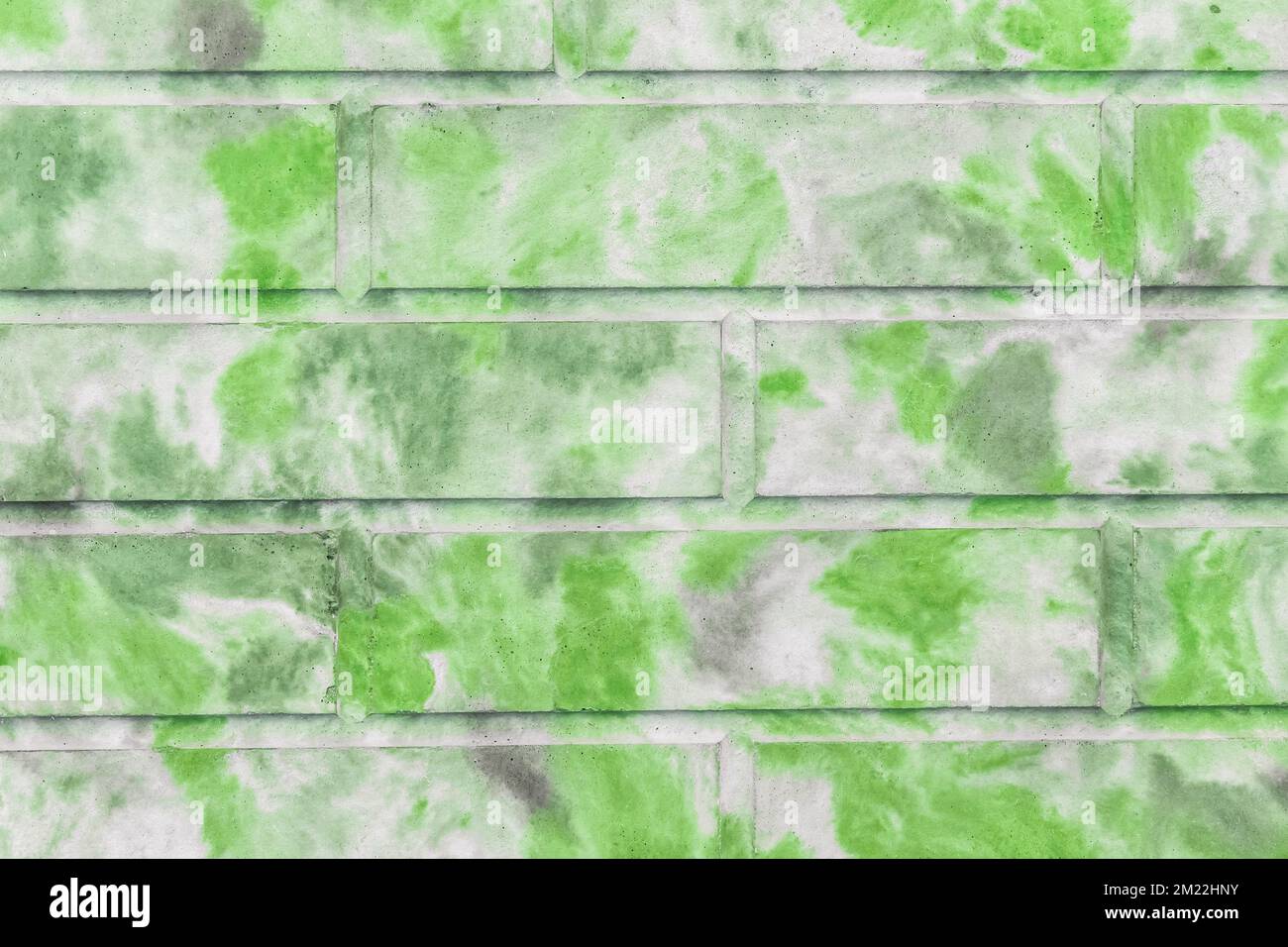 Dekorativer Ziegelsteinzaun abstraktes grünes, gepunktetes Farbmuster moderner Hintergrund für Innenwände. Stockfoto