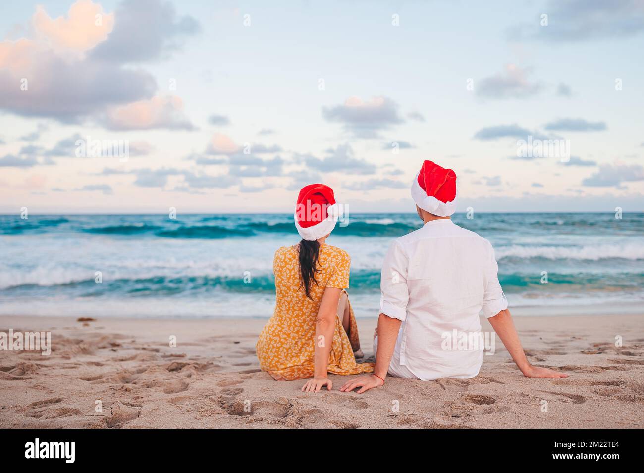 Glückliches Paar in Santa hat auf Weihnachtsstrandurlaub Stockfoto