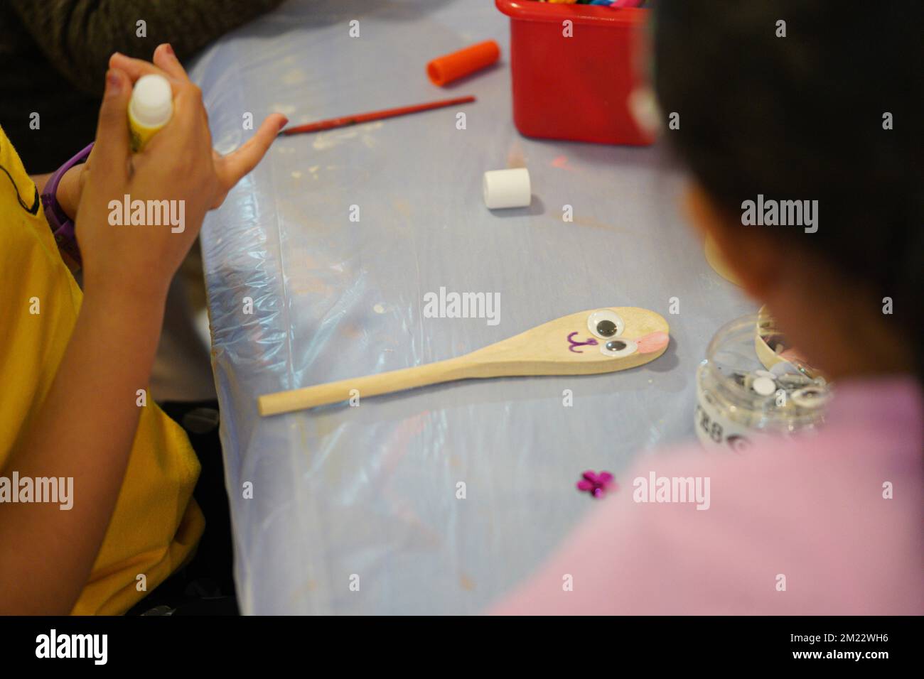 Kunst und Handwerk für Kinder. Ein kleines Kind, das Holzlöffel macht, Kunst und Kunsthandwerk. Stockfoto