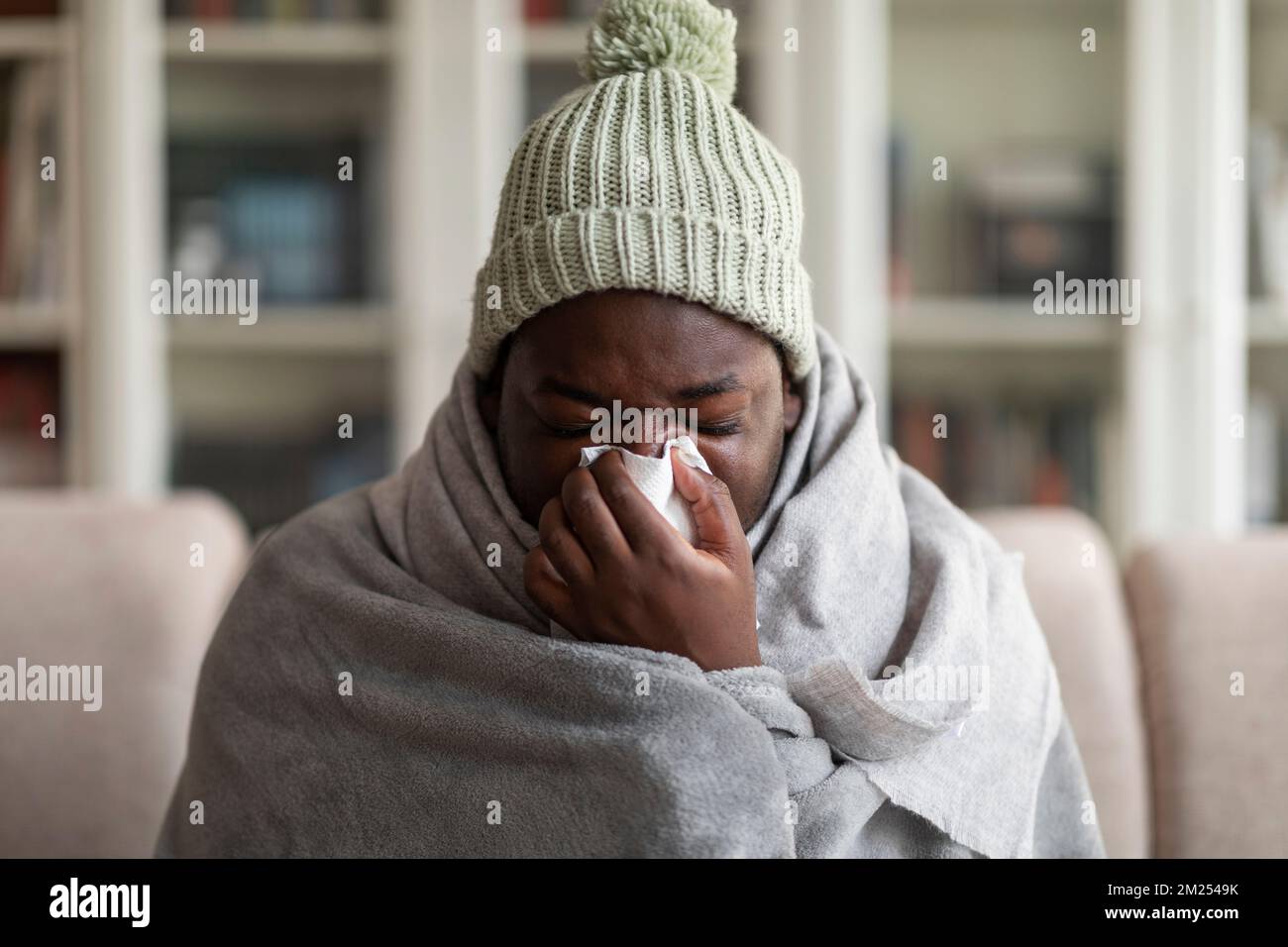 Kranker afroamerikaner, der Nase bläst, erkältet Stockfoto