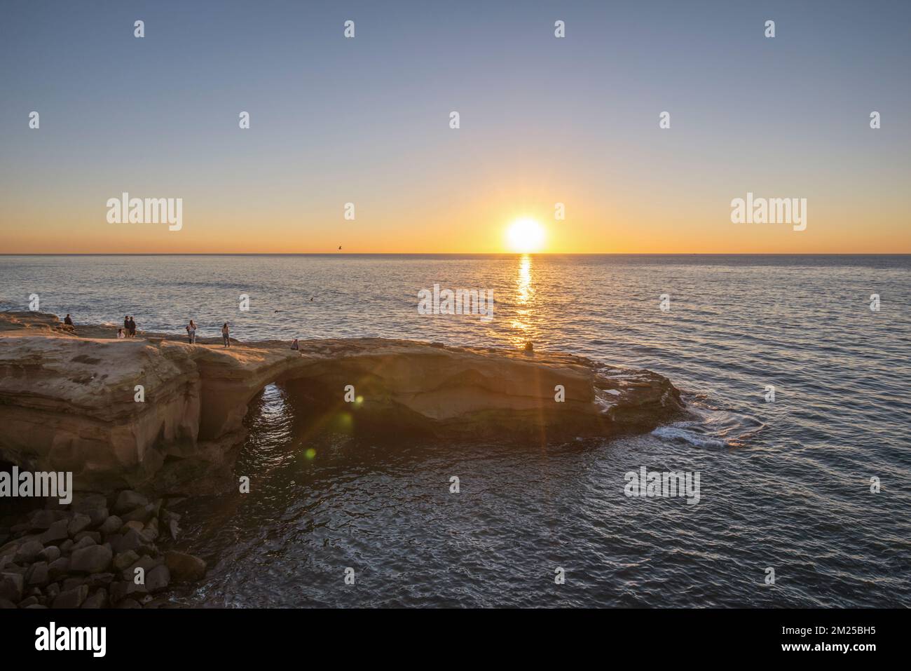 Ein klarer Himmel bei Sonnenuntergang vom Sunset Cliffs Natural Park im Winter. San Diego, Kalifornien, USA. Die Felsformation hier heißt "der Bogen". Stockfoto