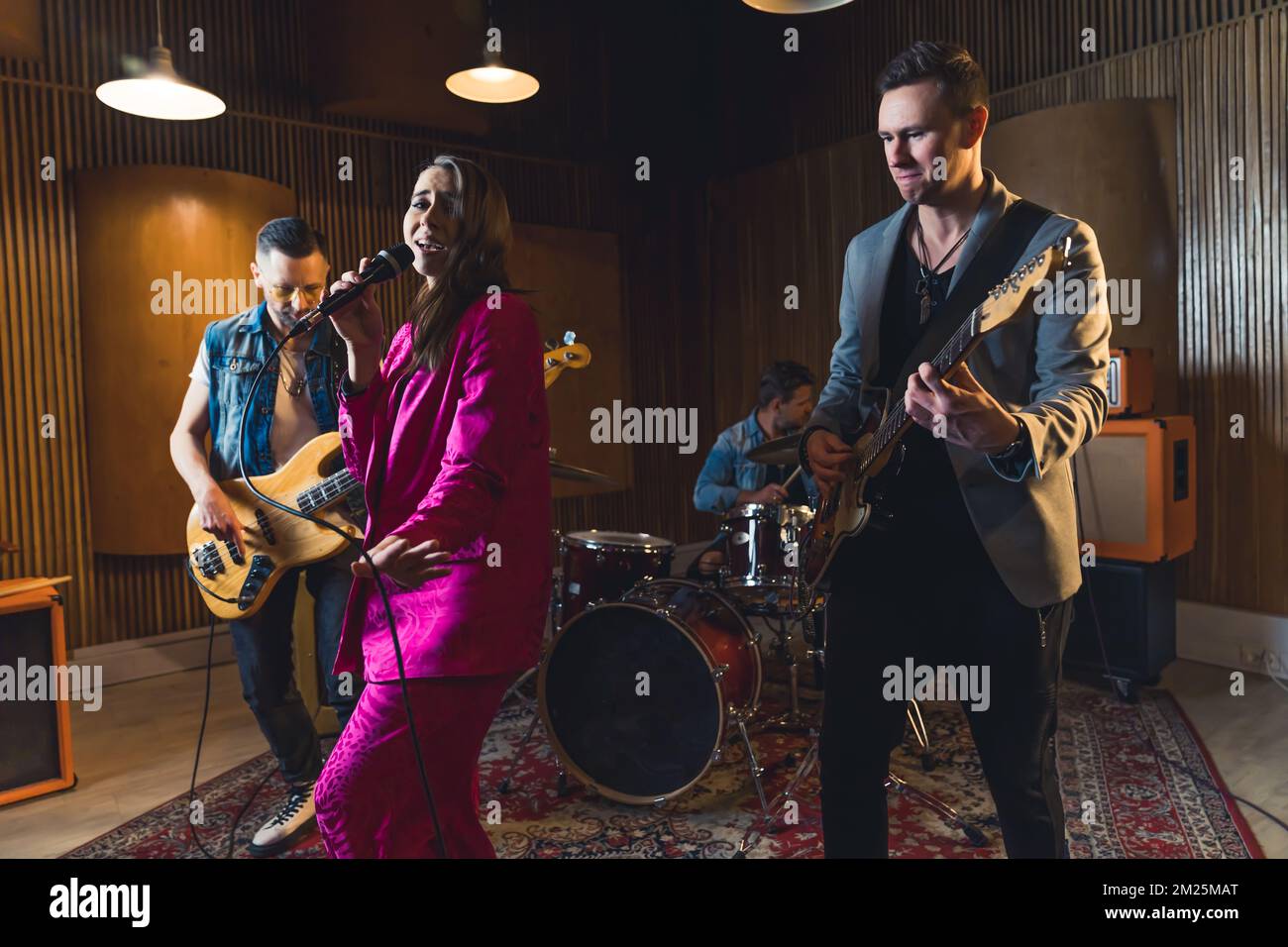 Vier-Personen-Band, die einen Song im Studio aufnimmt, ein Musikkonzept mit mittlerer Auflösung. Hochwertiges Foto Stockfoto