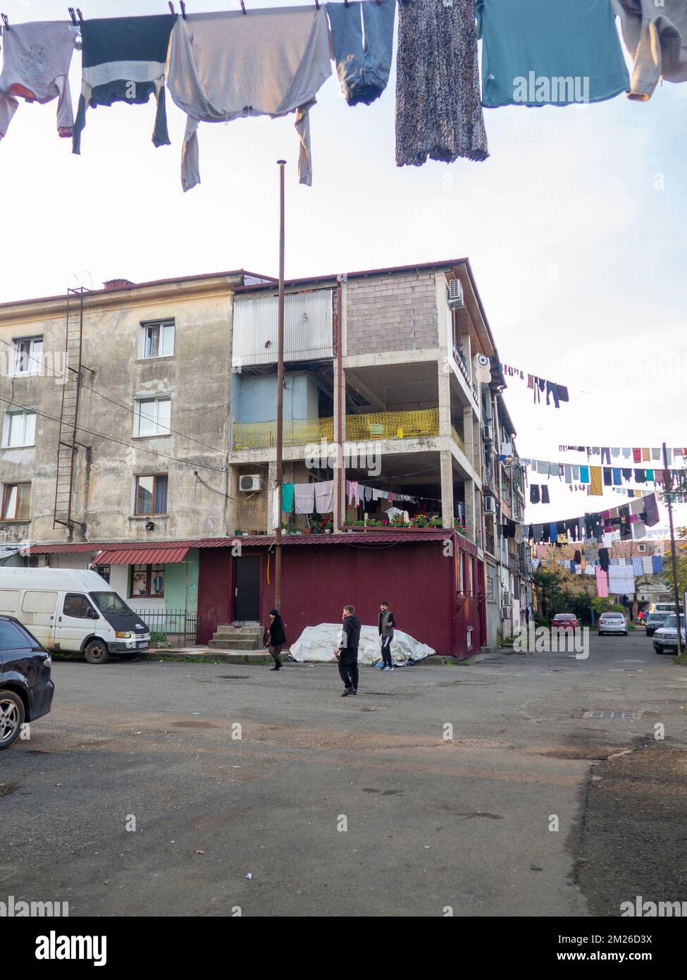 Leute im Hof. Wäsche wird an der Wäscheleine getrocknet. Städtische Umgebung. Asiatische Straßen. Gemütlicher Hof. Stockfoto