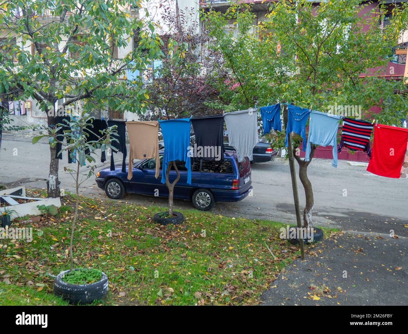 Leute im Hof. Wäsche wird an der Wäscheleine getrocknet. Städtische Umgebung. Asiatische Straßen. Gemütlicher Hof. Stockfoto